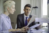 Homem e mulher revisando documento no escritório — Fotografia de Stock