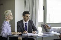Man and woman meeting with mature businessman — Stock Photo