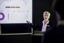 Жінка показує презентацію на проекційному екрані — стокове фото