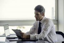 Man reading newspaper in office — Stock Photo