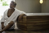 Hombre en albornoz relajante en la sauna - foto de stock