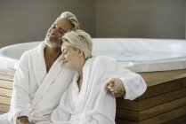 Casal em roupões de banho relaxante no spa — Fotografia de Stock