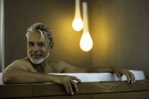 Retrato de hombre empapado en bañera de hidromasaje - foto de stock
