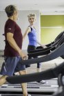 Man and woman exercising on treadmills — Stock Photo