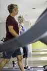 Mann und Frau trainieren auf Laufbändern — Stockfoto