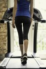 Back view of Woman exercising on treadmill — Stock Photo