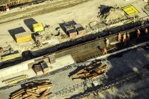 Вид с воздуха на работников в хардхатах на строительной площадке — стоковое фото