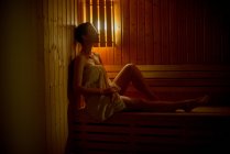 Young Woman relaxing in sauna — Stock Photo