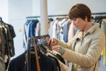 Frau kauft in Bekleidungsgeschäft ein — Stockfoto