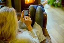 Жінка використовує смартфон вдома — стокове фото