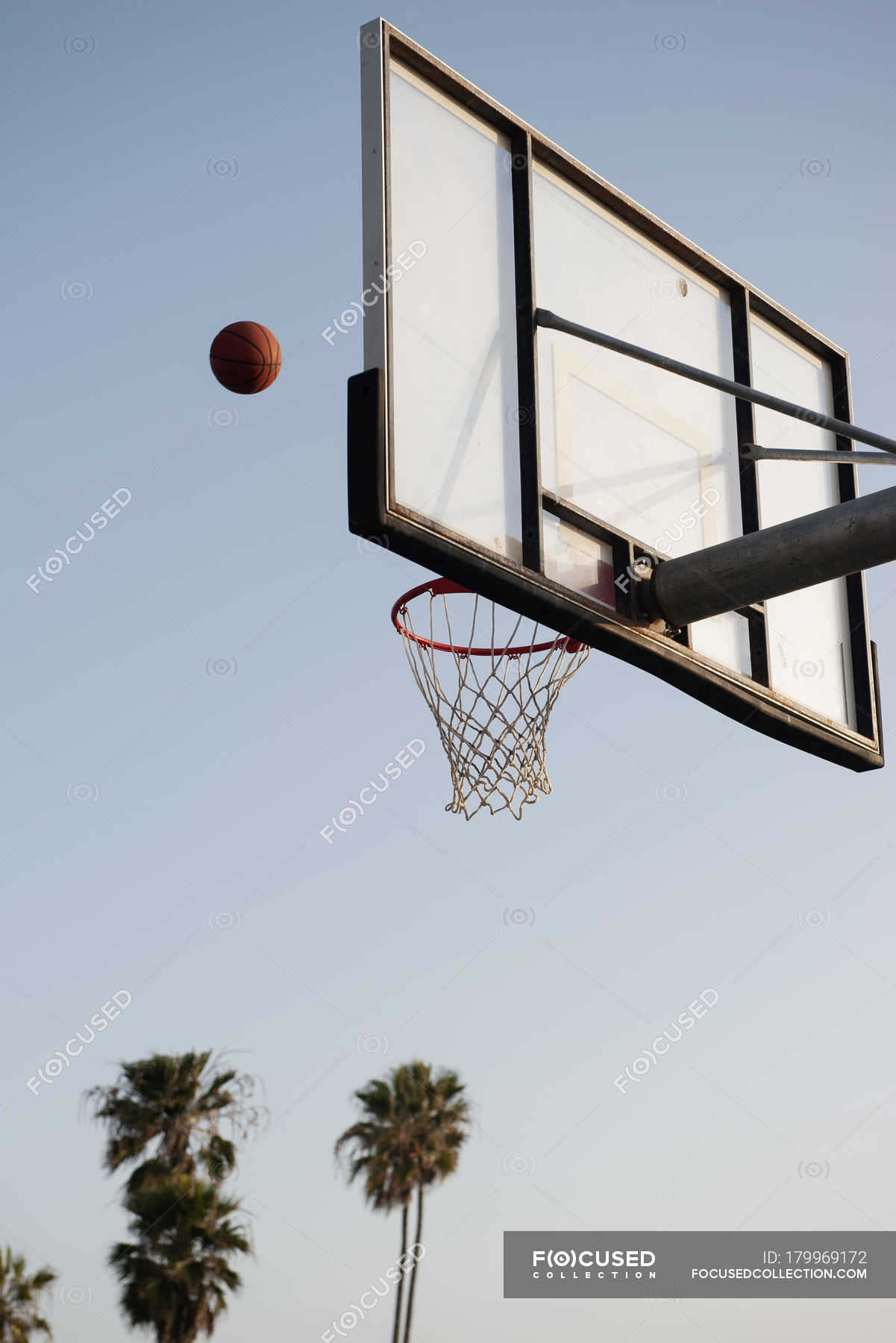 Basketball being thrown toward basketball hoop — viewed from below, low