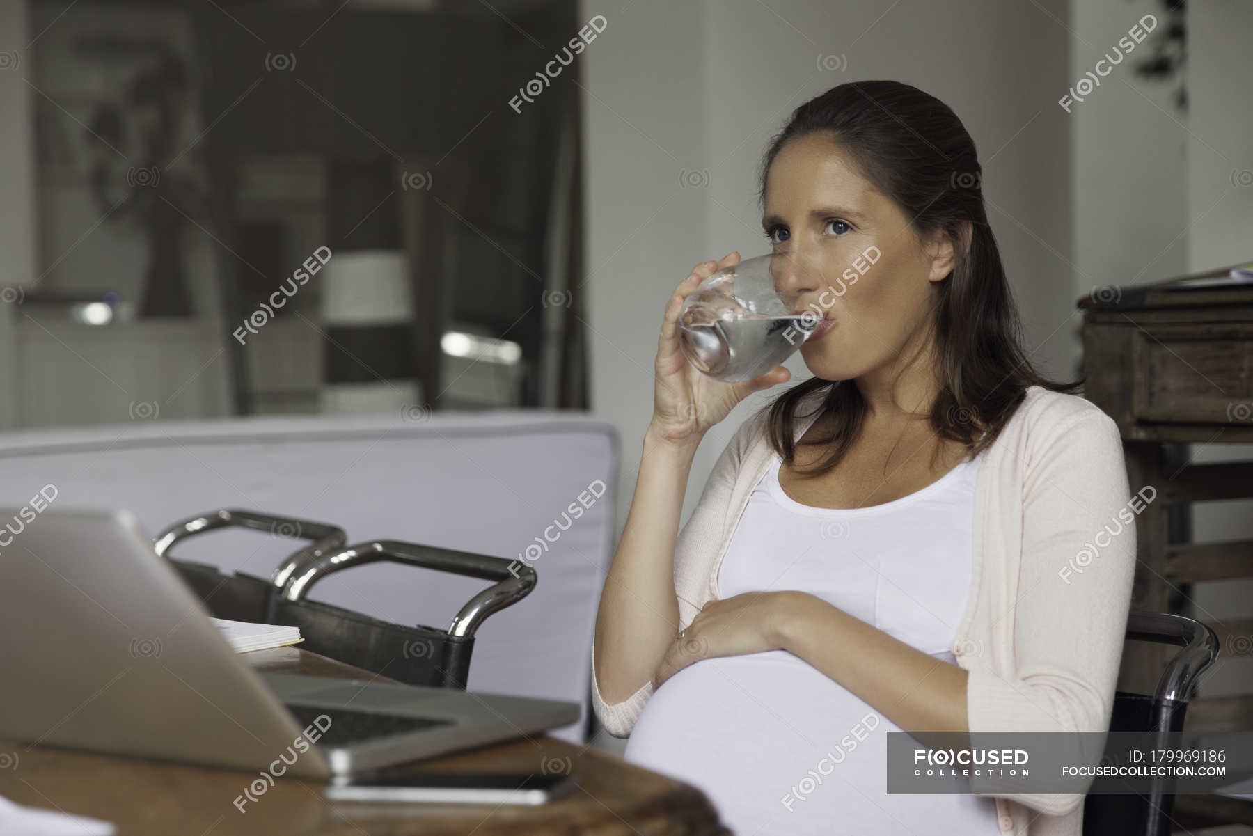 Pregnant woman drinking water from the glass — Mobile Phone, portrait ...