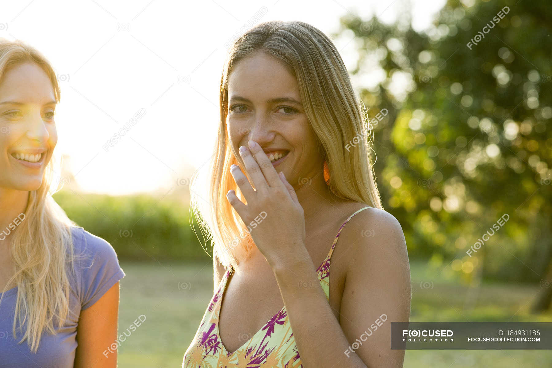 Two Women Laughing Together Outdoors Day Cropped Stock Photo