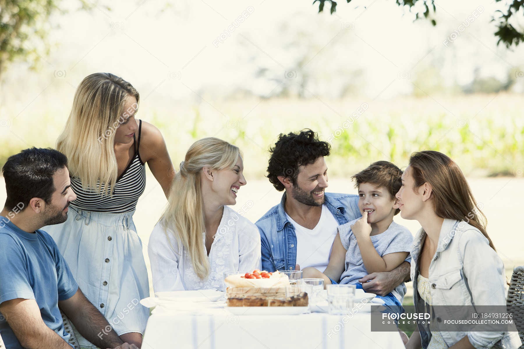 Family And Friends Spending Time Together Outdoors Eating Talking 