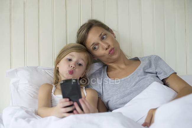 Madre e hija posando para selfie - foto de stock
