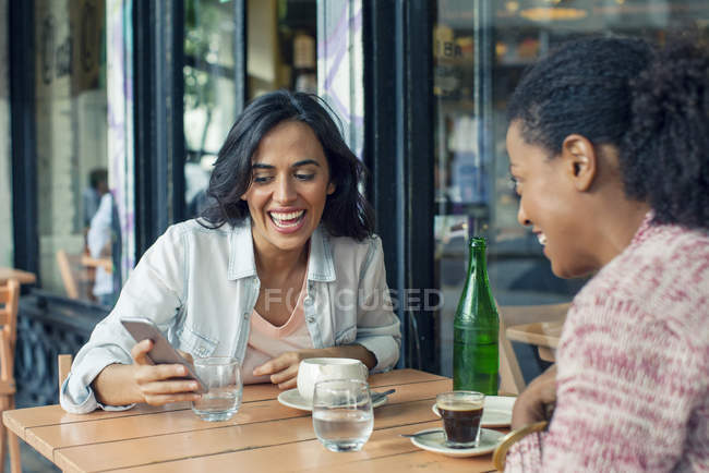 Встреча друзей в кафе на тротуаре — стоковое фото