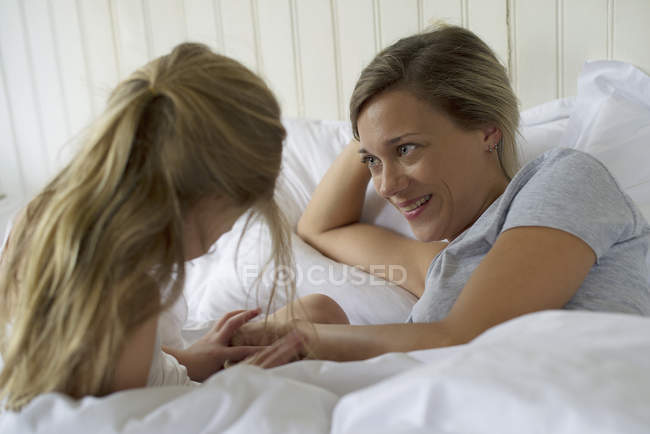 Mère et fille coller dans le lit — Photo de stock