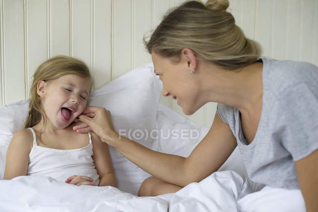 Мати і дочка склеювання в ліжку — стокове фото
