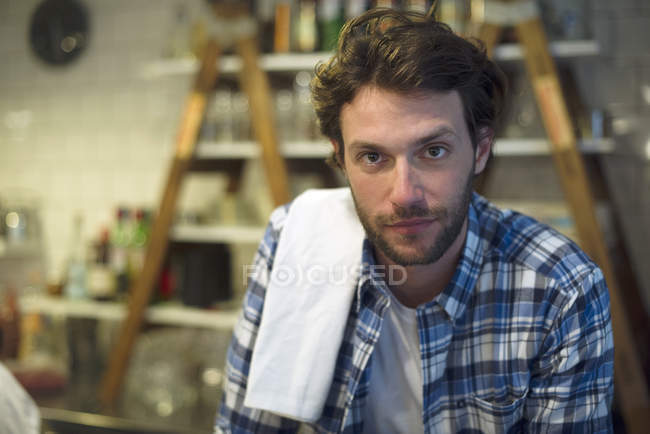 Ritratto del cameriere con asciugamano in cucina — Foto stock