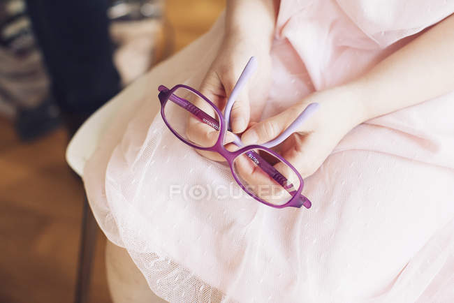 Girl holding pair of glasses — Stock Photo