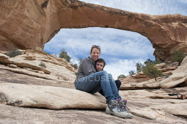 Mãe e filho sentados em frente à Ponte Owachomo, Monumento Nacional de Pontes Naturais, Utah, EUA — Fotografia de Stock