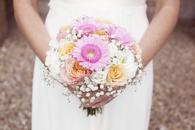 Bride holding bouquet of flowers — Stock Photo