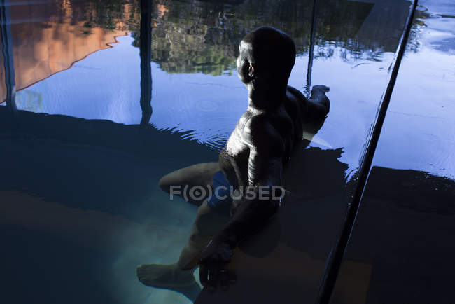 Africano americano Homem relaxante na piscina interior — Fotografia de Stock