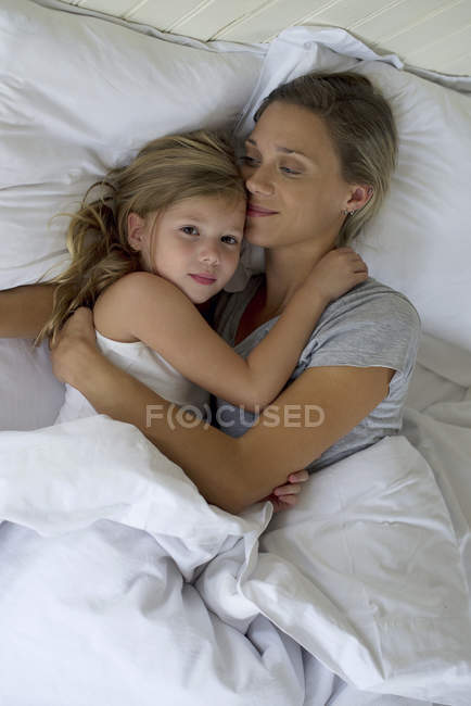 Mutter und Tochter umarmen sich im Bett — Stockfoto