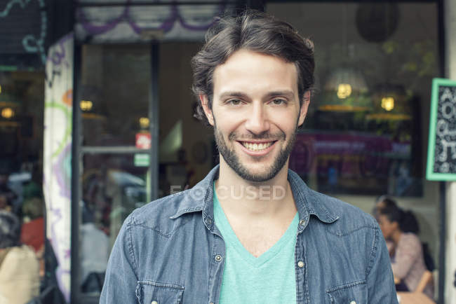 Homme debout devant le café, portrait — Photo de stock