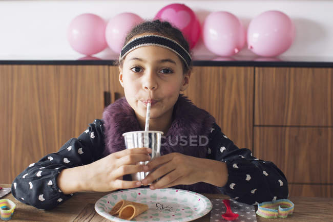Девушка пьет через соломинку — стоковое фото