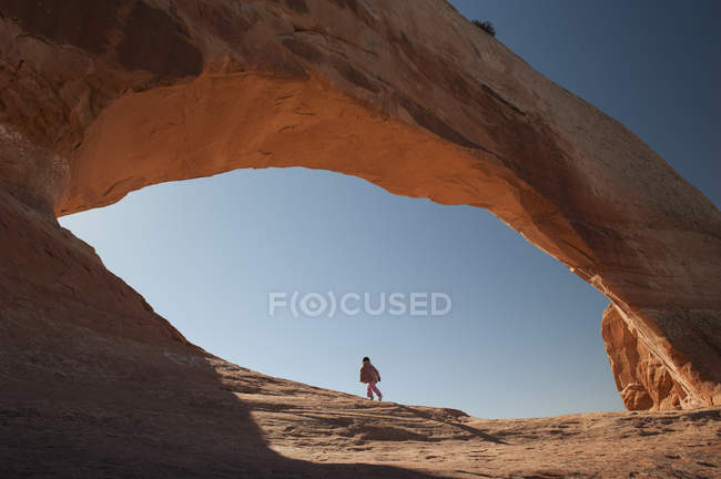 Kind läuft unter natürlichem Bogen in utah, USA — Stockfoto