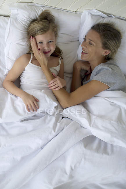 Mutter und Tochter liegen zusammen im Bett — Stockfoto