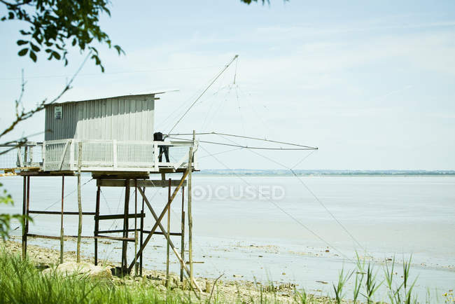 Cabana de pesca em palafitas perto da borda da água — Fotografia de Stock