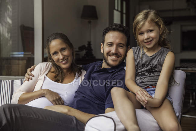 Retrato Família sentada no sofá em casa juntos — Fotografia de Stock
