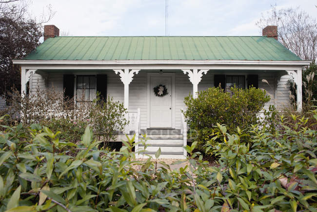 Extérieur de la petite maison avec cour verte — Photo de stock
