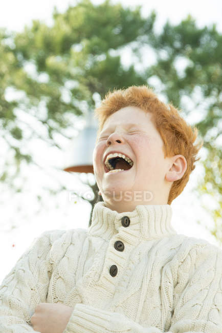 Портрет рыжеволосого мальчика, смеющегося на улице — стоковое фото