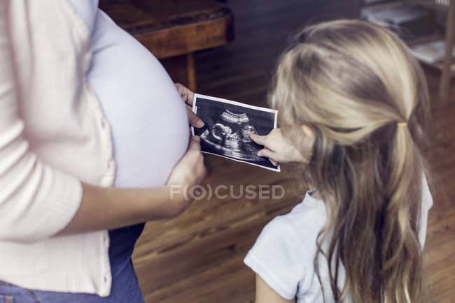 Mother showing daughter ultrasound photo — Stock Photo