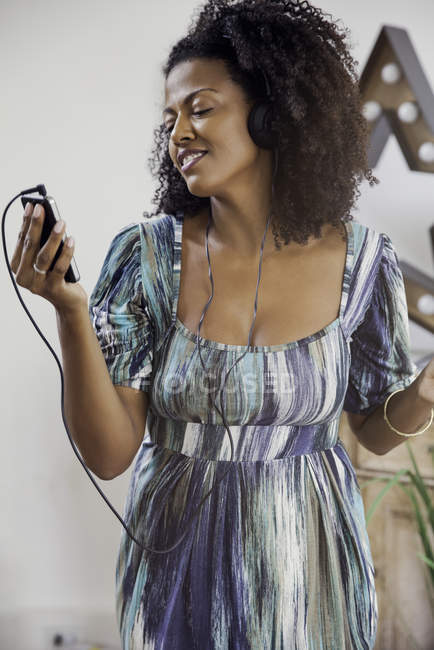 Женщина слушает музыку на смартфоне — стоковое фото