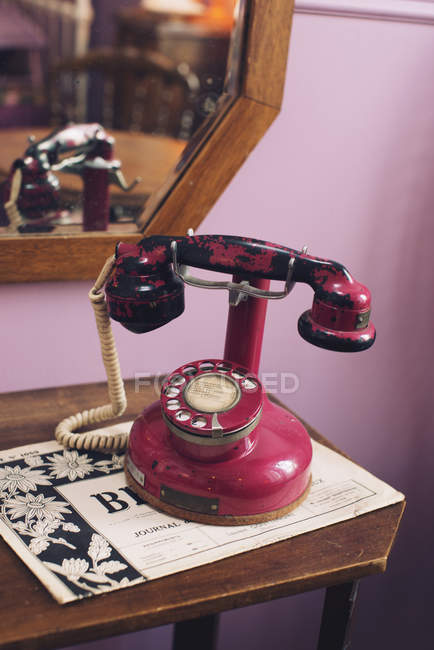 Крупным планом красный антикварный телефон на столе — стоковое фото