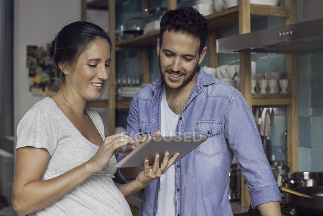 Couple using digital tablet together at home — Stock Photo
