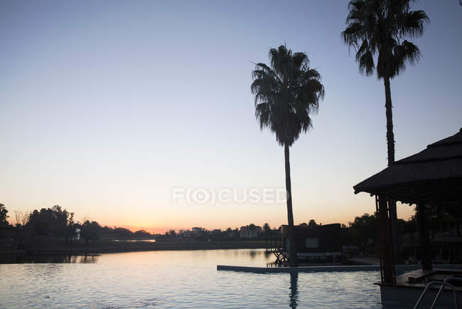 Tranquil sunset over lake with villas — Stock Photo