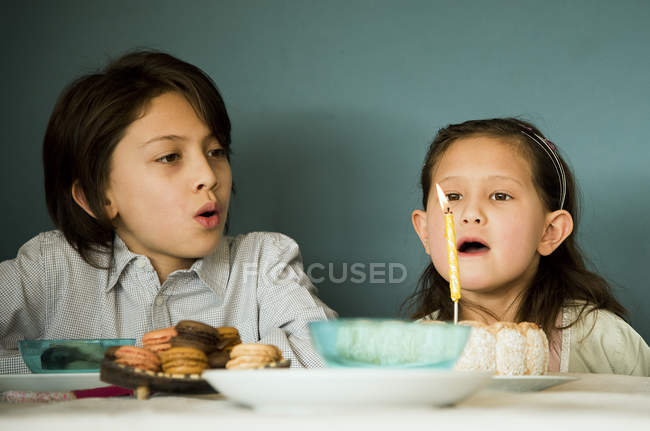Girl blowing out candle on birthday cake — Stock Photo