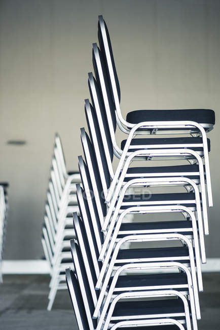 Pilhas de cadeiras em sala de escritório vazia — Fotografia de Stock