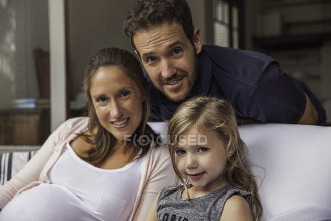 Портрет сім'ї з донькою сидить на дивані вдома — стокове фото