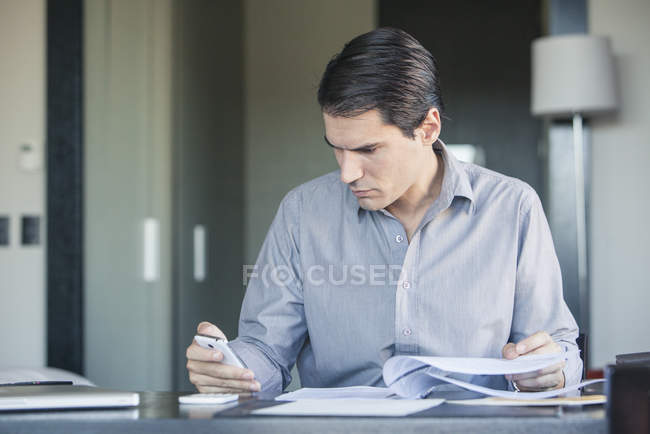Geschäftsmann checkt Smartphone im Büro — Stockfoto