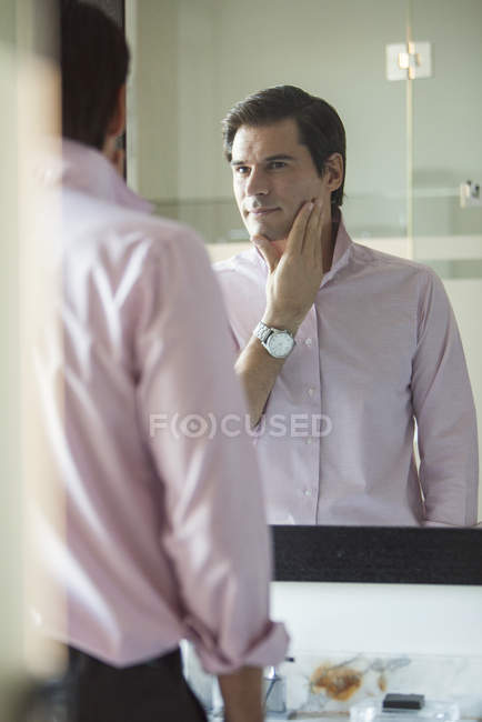 Retrato del hombre escrutándose en el espejo - foto de stock