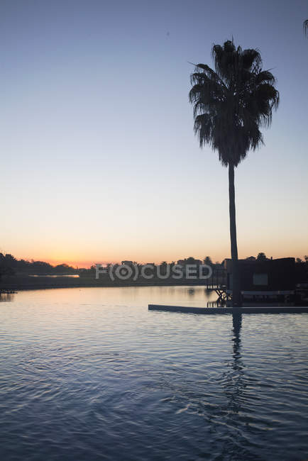 Tranquil sunset over lake with villa — Stock Photo