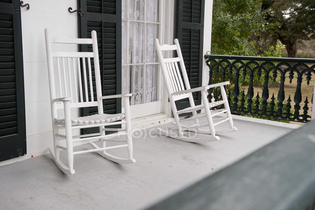 Duas cadeiras de balanço no alpendre da casa — Fotografia de Stock
