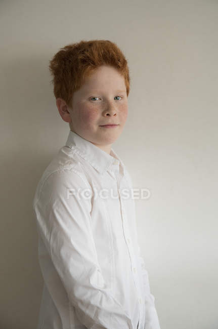 Портрет мальчика с рыжими волосами на сером фоне — стоковое фото