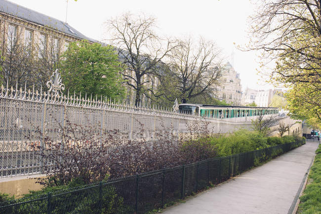 Commuter train driving on the street of the city — Stock Photo